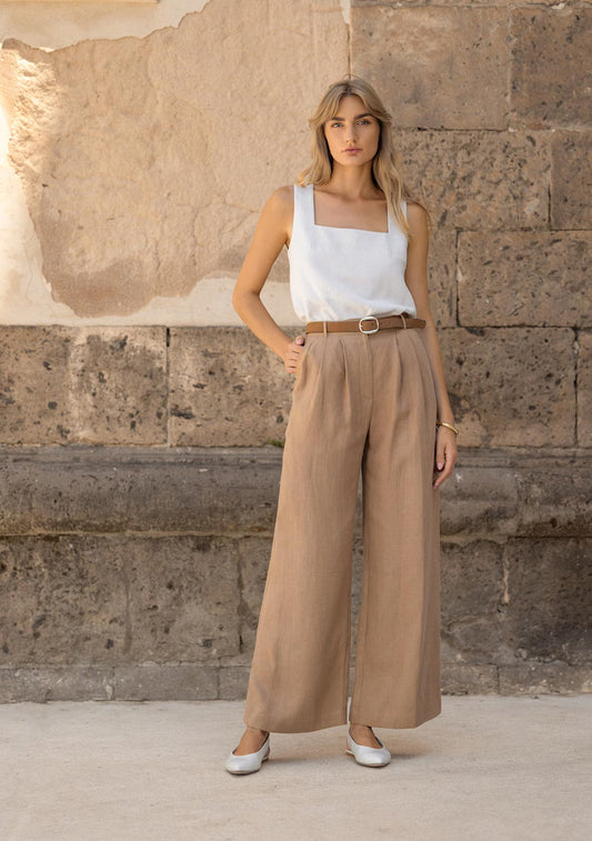 Pantalon femme beige à coupe large et taille haute porté avec un top blanc