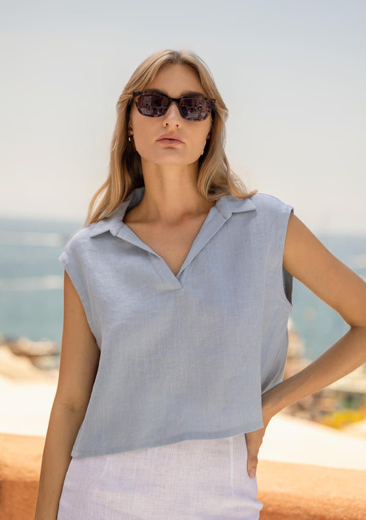 Top femme bleu clair sans manches à col chemise porté en bord de mer